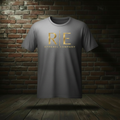 Rogue Standard Gold Tee in Ash on a ghost form against a dark brick wall and wood floor