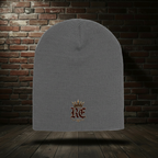 Charcoal RE Crest knit hat on a dark red-and-black brick boutique background