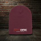 Manifest Destiny Knit Hat in Maroon with the exact Empire Globe Crest Bomber boutique background